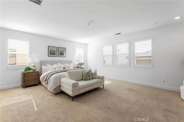 a spacious bedroom with a bed and a couch