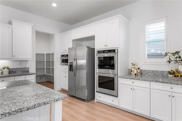 a kitchen with stainless steel appliances granite countertop a refrigerator and a sink
