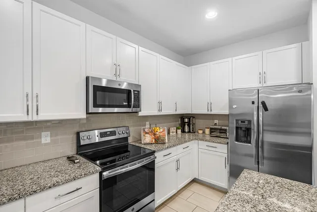 a kitchen with stainless steel appliances granite countertop a refrigerator sink and stove
