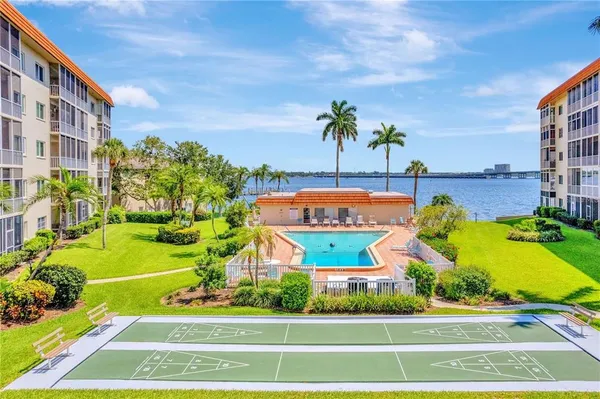 a view of a swimming pool with a yard and plants