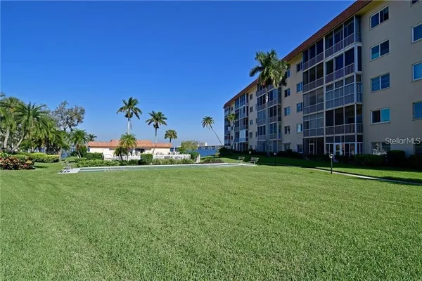 a view of a big building with big yard and large trees