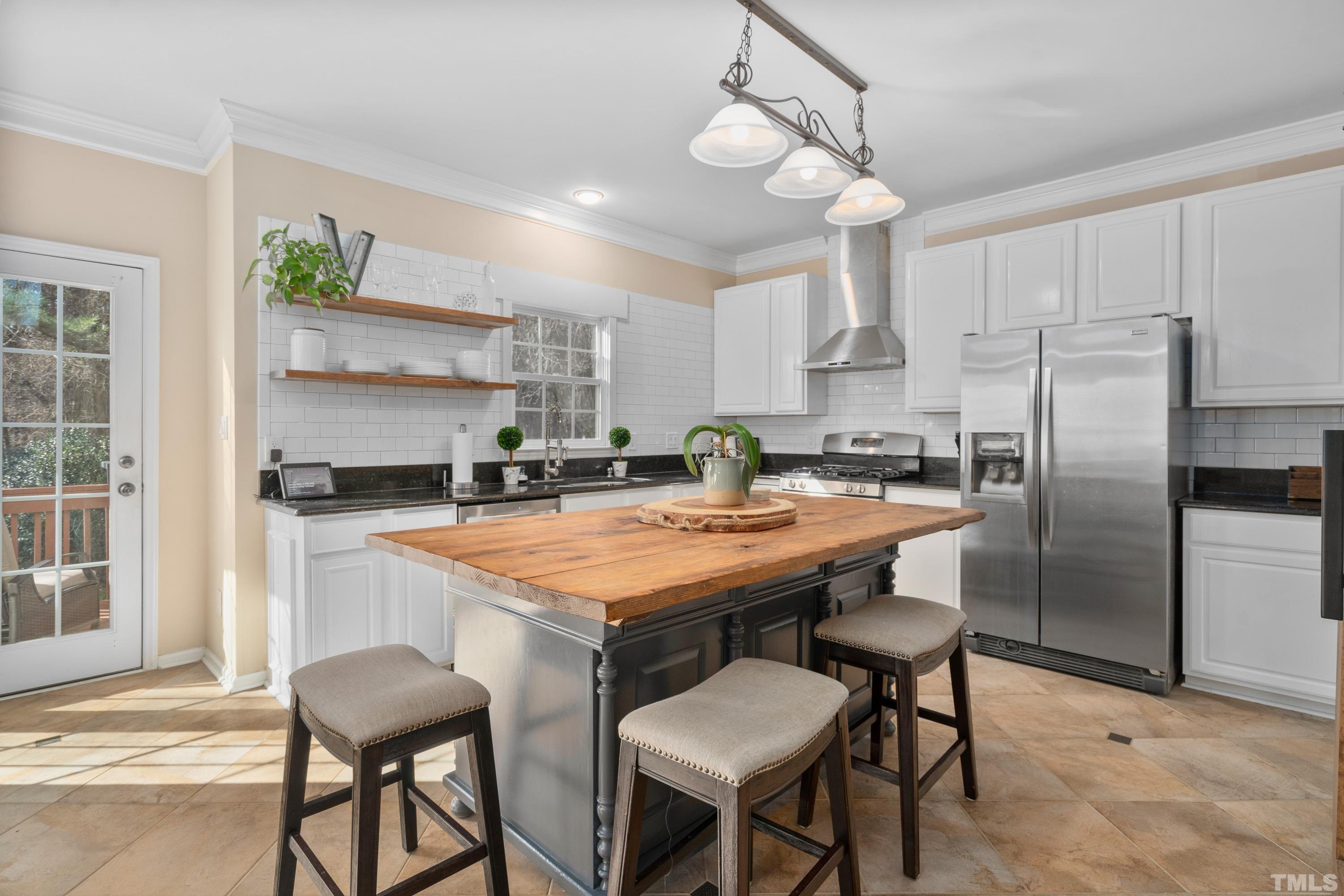 7405 Dorrington Trail Raleigh, NC 27615 - Photo 13 of 31 a kitchen with stainless steel appliances a table chairs and chandelier