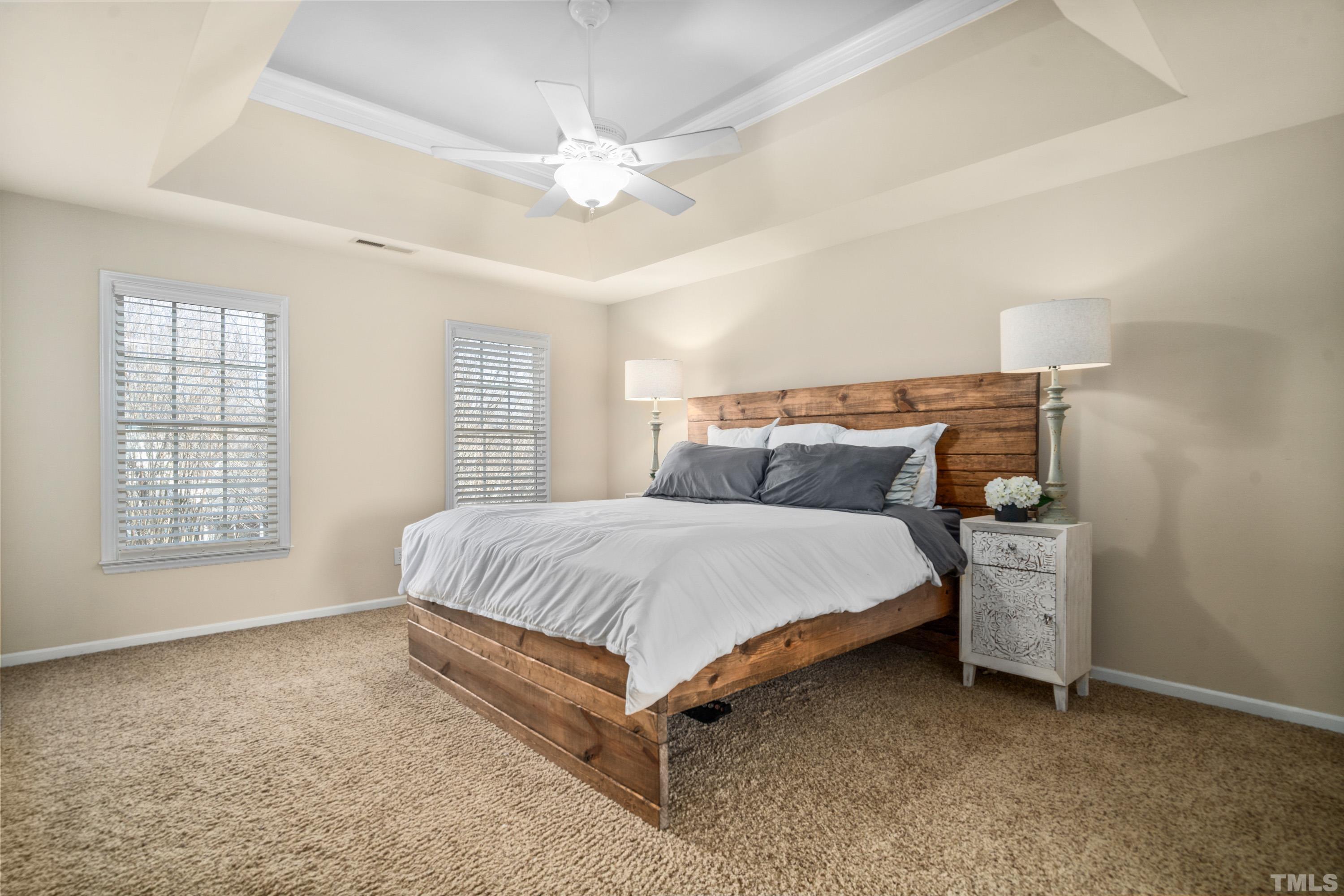 7405 Dorrington Trail Raleigh, NC 27615 - Photo 18 of 31 a spacious bedroom with a bed and a chandelier