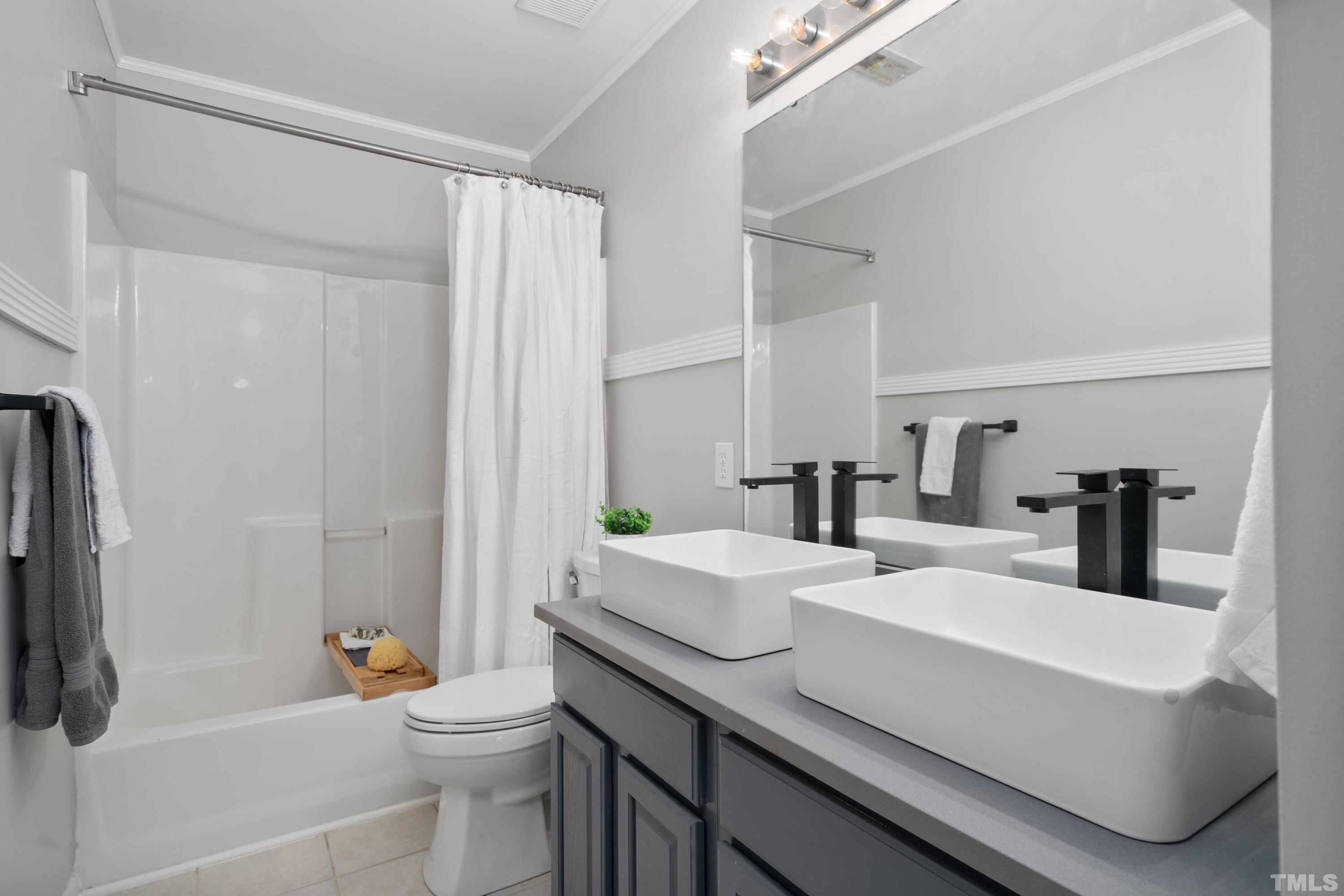 7405 Dorrington Trail Raleigh, NC 27615 - Photo 22 of 31 a bathroom with a sink a toilet a mirror and shower