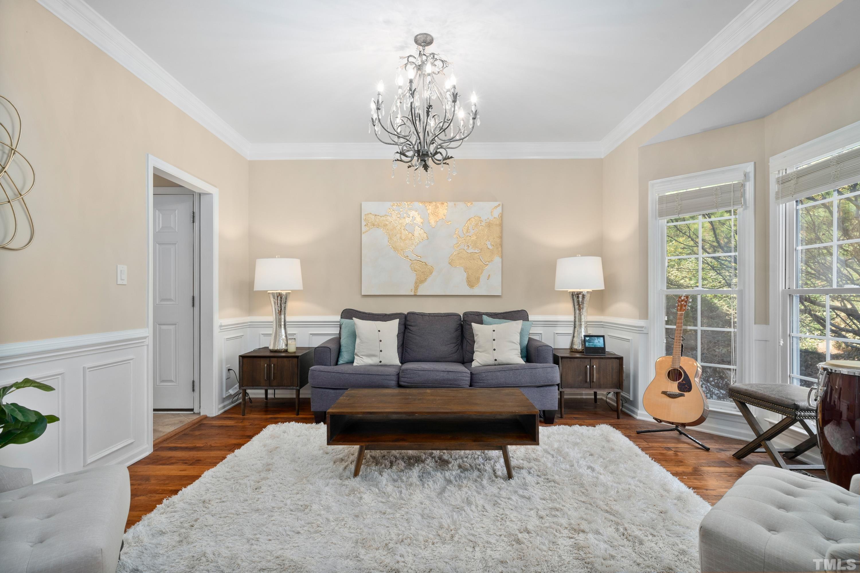 7405 Dorrington Trail Raleigh, NC 27615 - Photo 6 of 31 a living room with furniture a chandelier and a rug