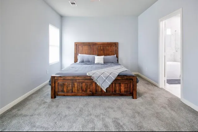 a bedroom with a bed and a window