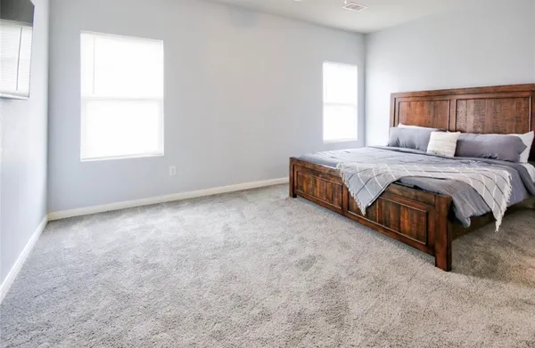 a spacious bedroom with a bed and window