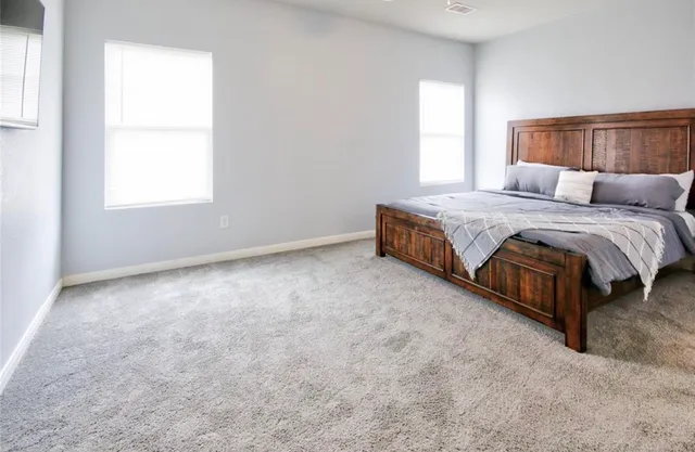 a spacious bedroom with a bed and window
