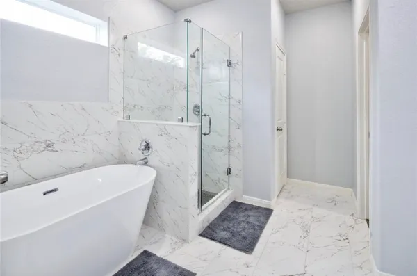 a bathroom with a tub a toilet and a shower