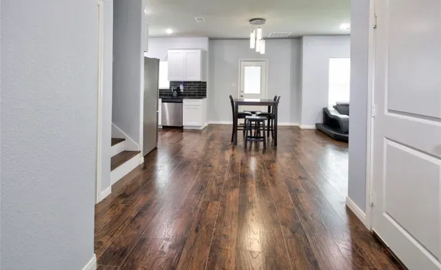 a view of a kitchen and dining room with wooden floor