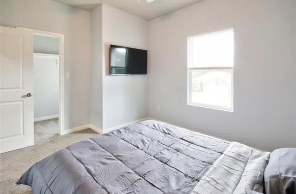 a bedroom with a bed and a flat screen tv