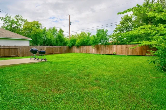 a view of a backyard with a garden and wooden fence