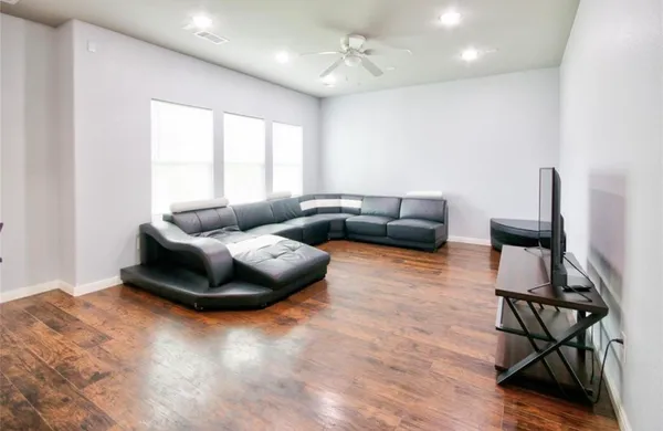 a living room with furniture and a wooden floor