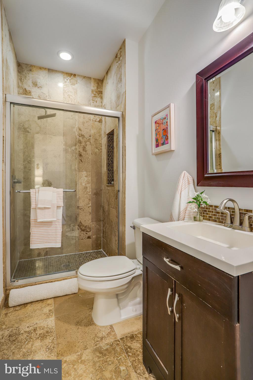 343 11th Street Southeast Washington, DC 20003 - Photo 25 of 37 Limestone tiled ensuite shower w/storage vanity