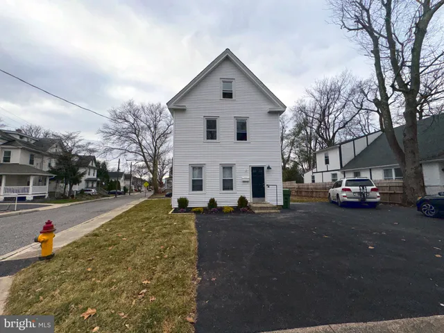 a view of a white house in a city street