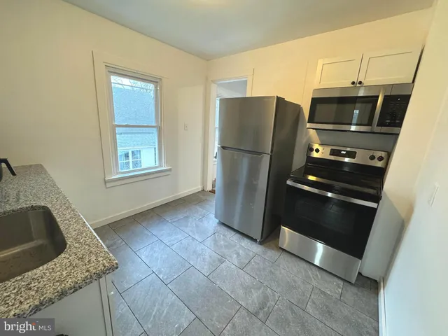 a kitchen with granite countertop a refrigerator and a stove
