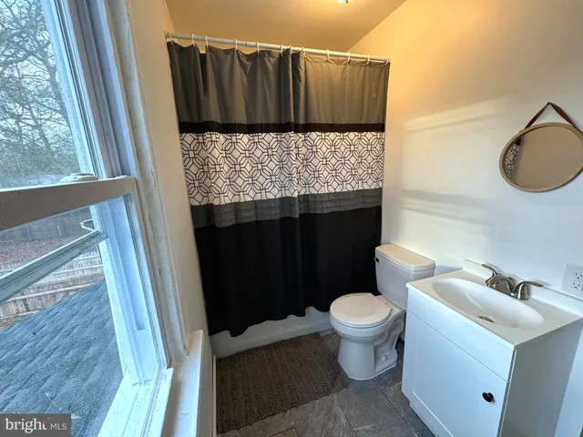 a bathroom with a granite countertop toilet and a sink