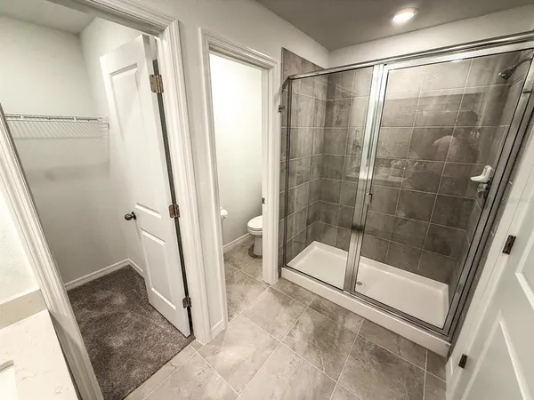 a white toilet sitting next to a small bathroom