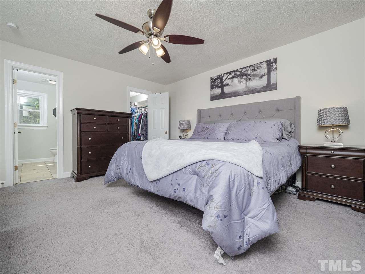 6108 Bur Trail Raleigh, NC 27616 - Photo 14 of 30 a spacious bedroom with a bed and a chandelier