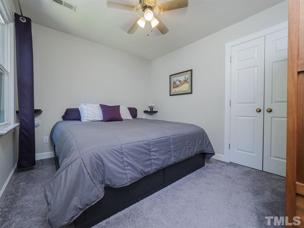 6108 Bur Trail Raleigh, NC 27616 - Photo 23 of 30 a bedroom with a bed and a chandelier