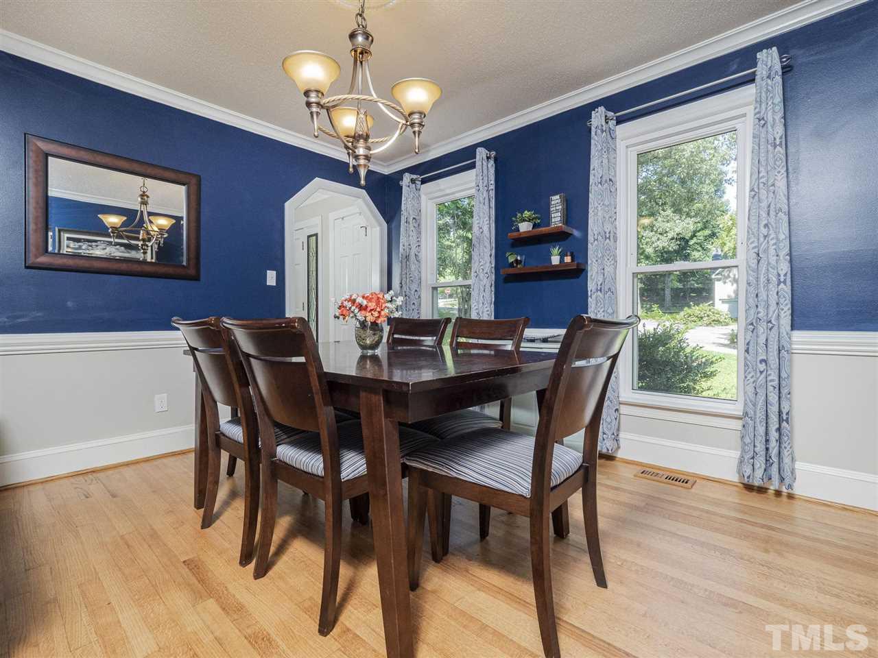 6108 Bur Trail Raleigh, NC 27616 - Photo 10 of 30 a dining room with wooden floor a chandelier a wooden table and chairs