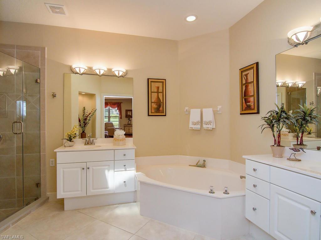 104 Napa Ridge Way Naples, FL 34119 - Photo 20 of 29 a bathroom with a bathtub a sink and a mirror