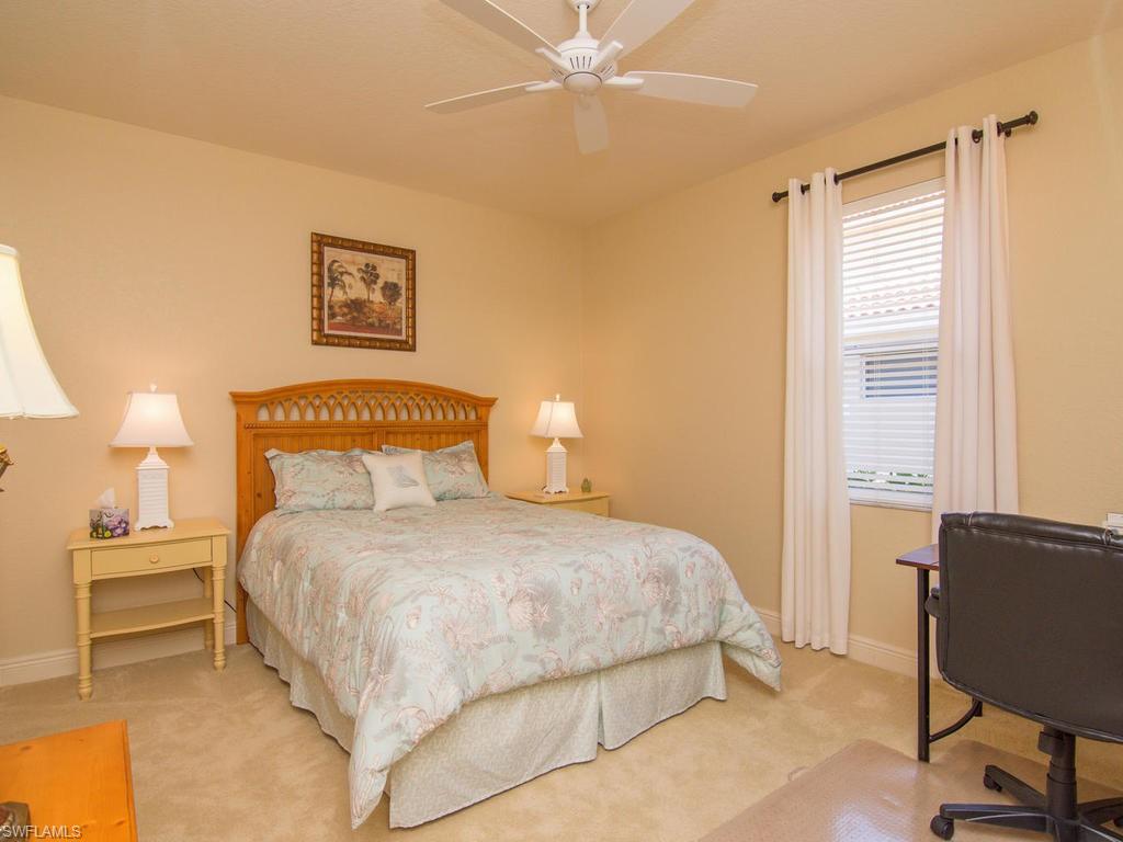 104 Napa Ridge Way Naples, FL 34119 - Photo 22 of 29 a bedroom with a bed and a lamp with potted plant