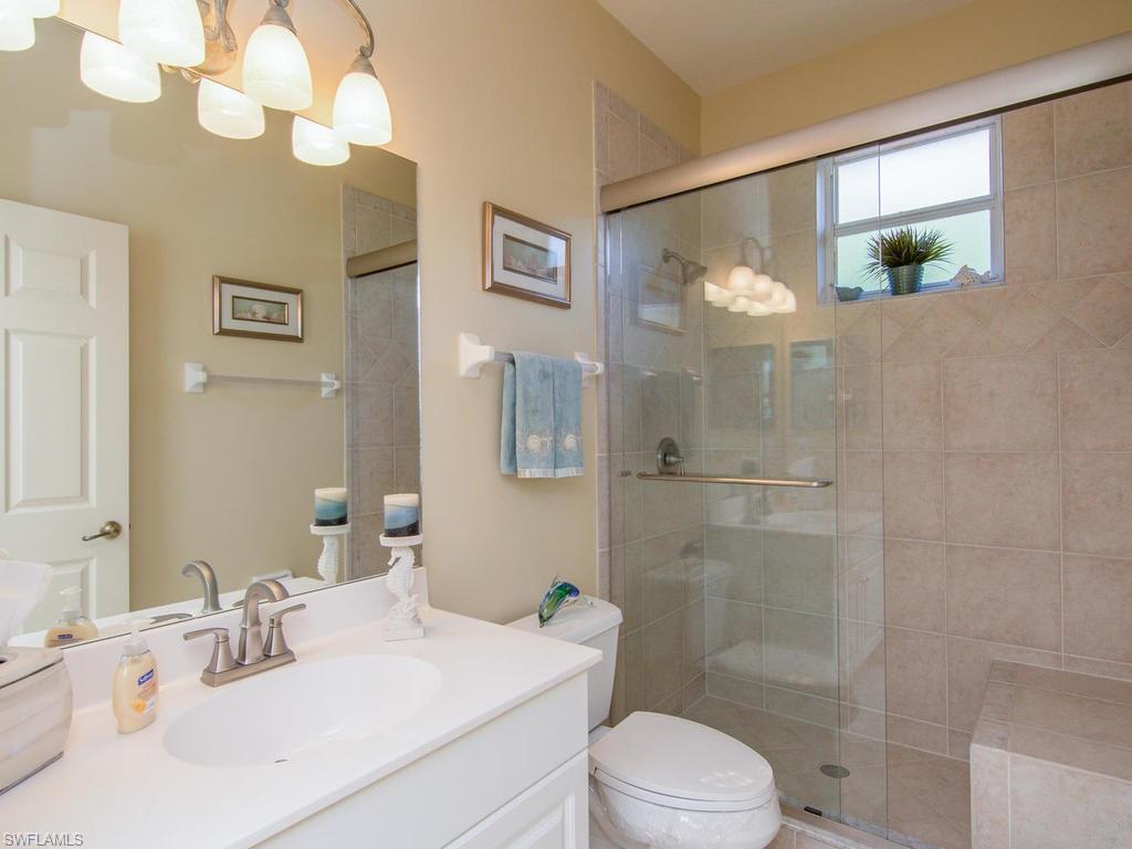 104 Napa Ridge Way Naples, FL 34119 - Photo 23 of 29 a bathroom with a sink a toilet and shower