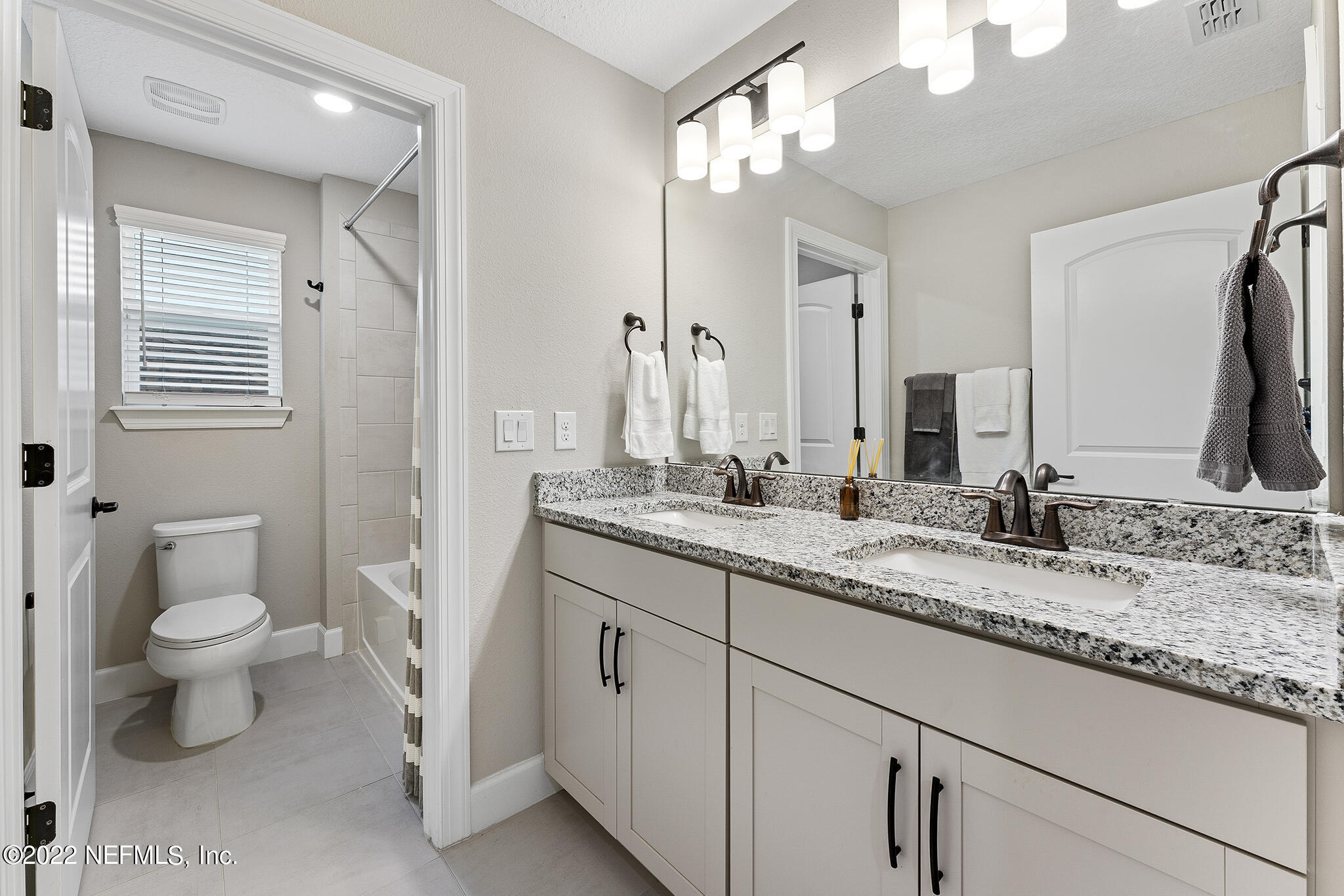 211 Orchard Lane St. Augustine, FL 32095 - Photo 35 of 59 a bathroom with a granite countertop sink a toilet and a mirror