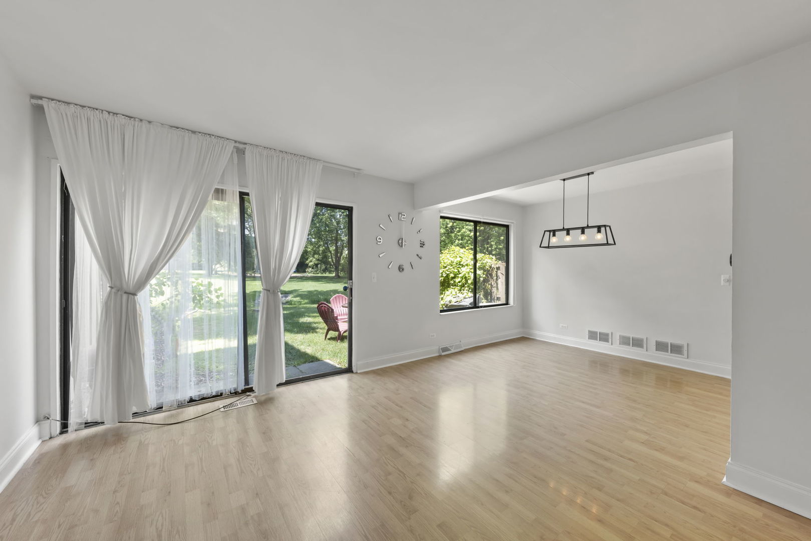 698 Circle Drive Roselle, IL 60172 - Photo 6 of 31 a view of an empty room with a window and wooden floor