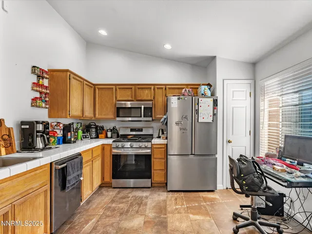 a kitchen with stainless steel appliances granite countertop a refrigerator stove top oven and sink