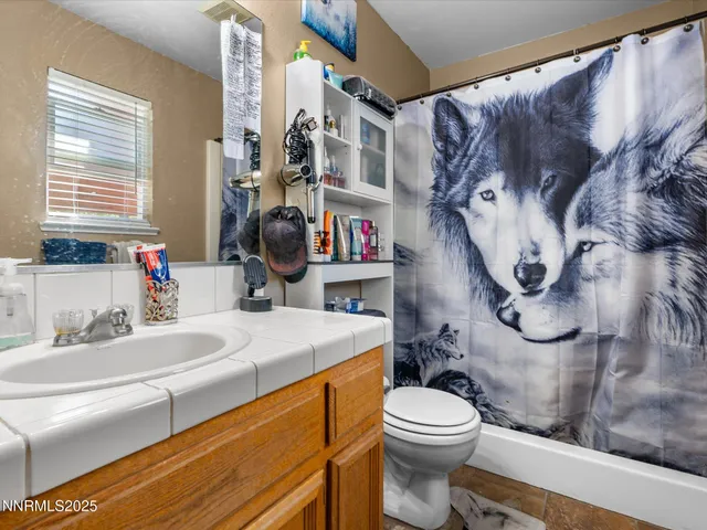 a bathroom with a sink a toilet and a shower curtain