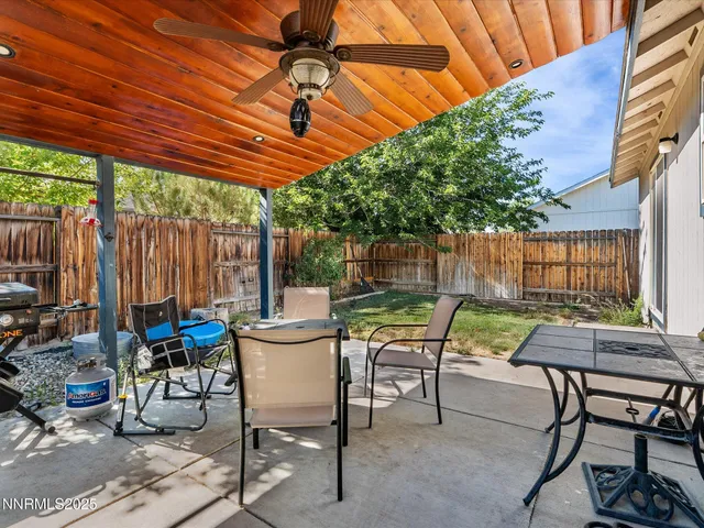 a view of patio with table and chairs and backyard