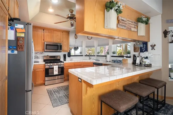 a kitchen with stainless steel appliances granite countertop a sink a stove and a refrigerator