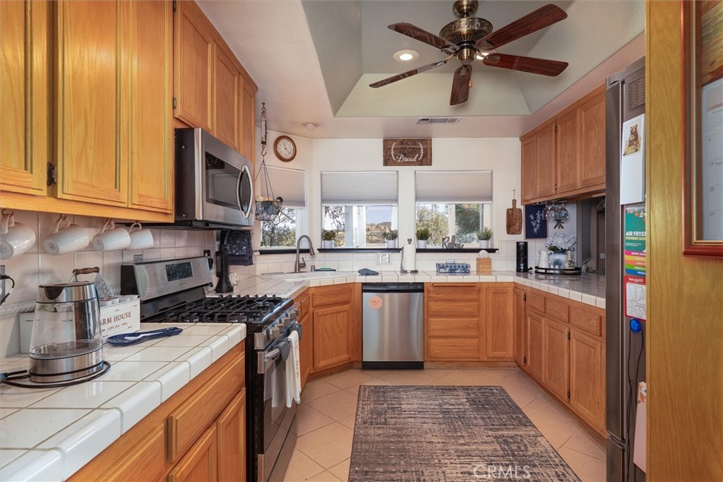 46455 Konklin Road Coarsegold, CA 93614 - Photo 16 of 46 a kitchen with stainless steel appliances granite countertop a sink a stove and a refrigerator