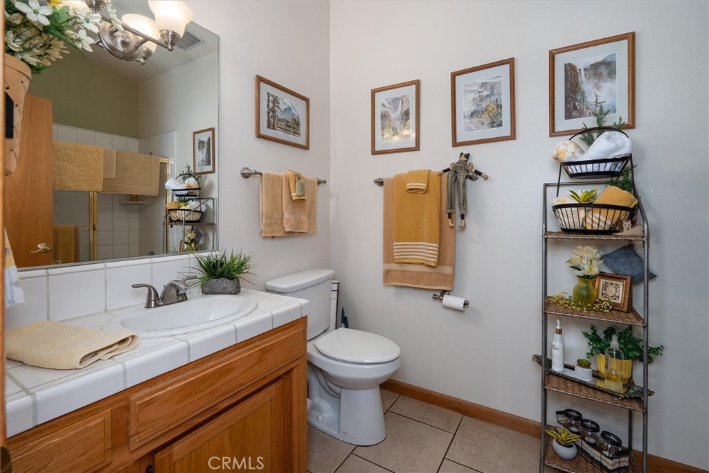 46455 Konklin Road Coarsegold, CA 93614 - Photo 24 of 46 a bathroom with a granite countertop toilet sink and mirror