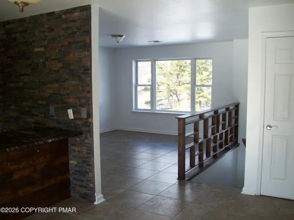 an empty room with wooden floor closet and windows