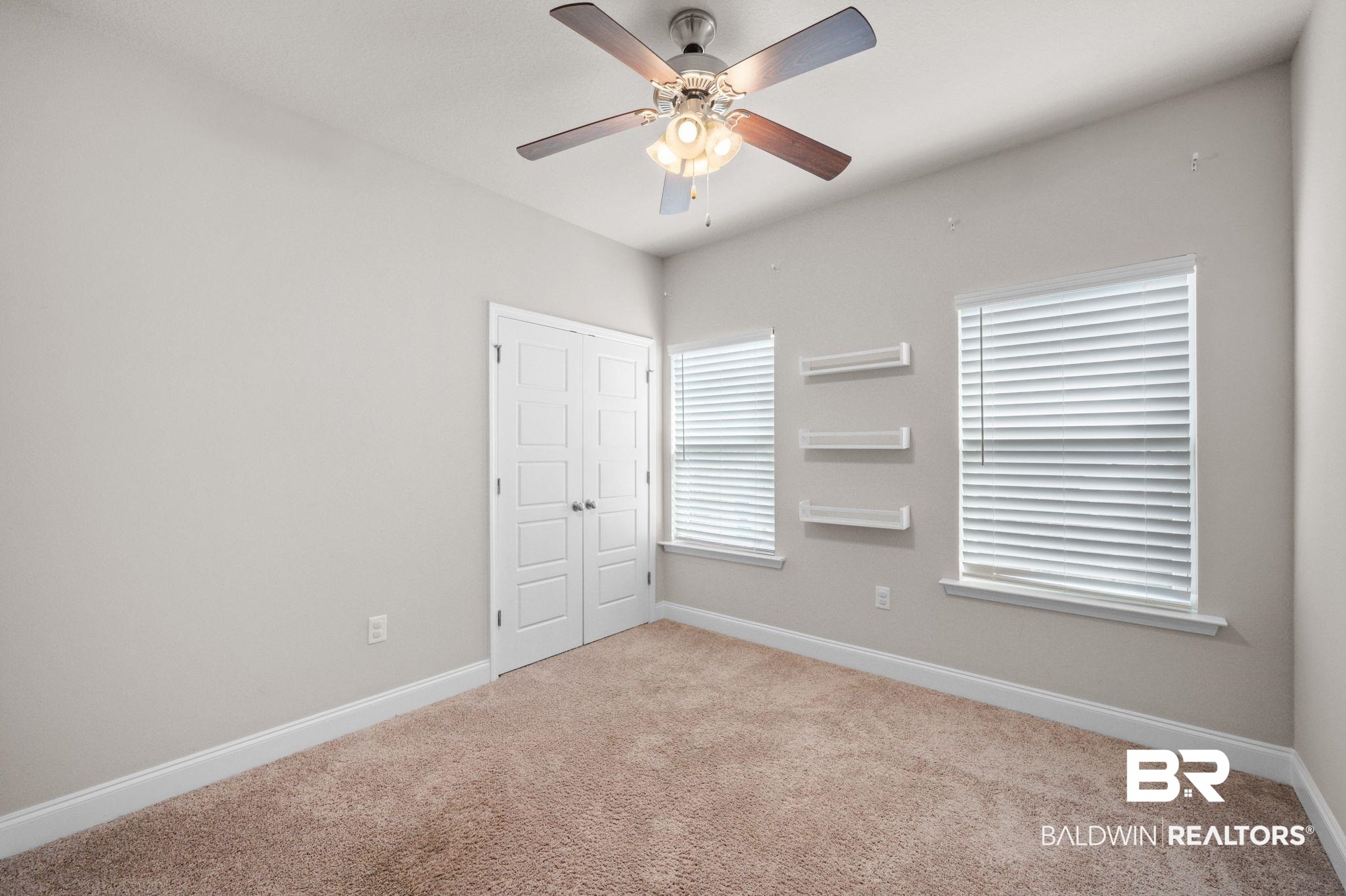 6903 Spaniel Drive, Unit B Spanish Fort, AL 36527 - Photo 17 of 28 Unfurnished bedroom with ceiling fan, baseboards, a closet, and light colored carpet