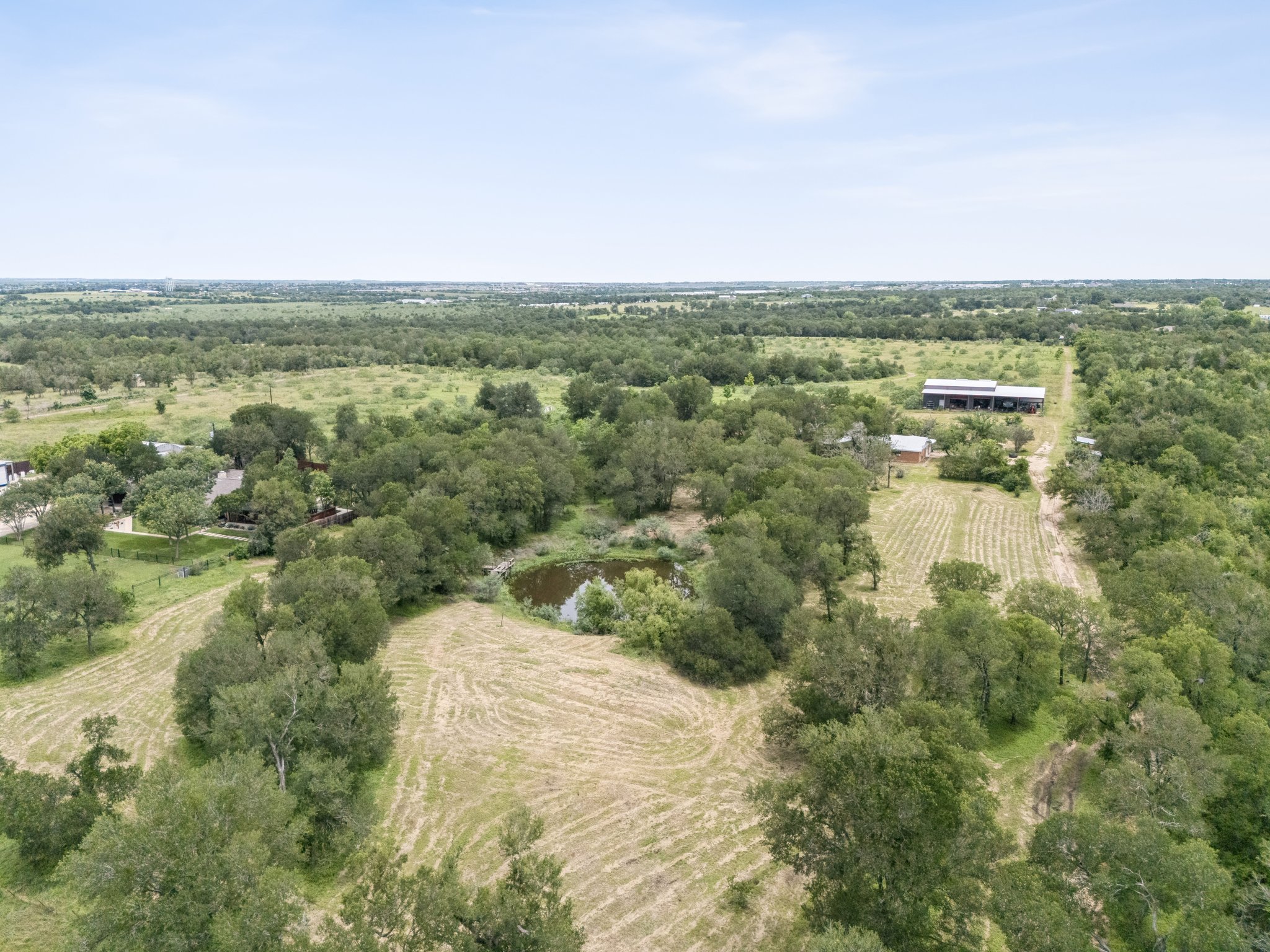 406 Monkey Road Elgin, TX 78621 - Photo 33 of 39 Expansive rural property featuring an abundance of mature trees, open fields, and a private pond