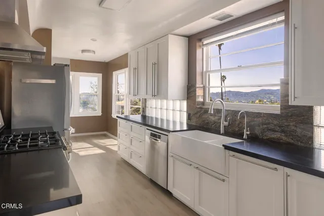 a kitchen with stainless steel appliances a stove a refrigerator and a stove
