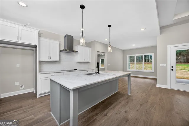 a kitchen with a sink stove and wooden floor