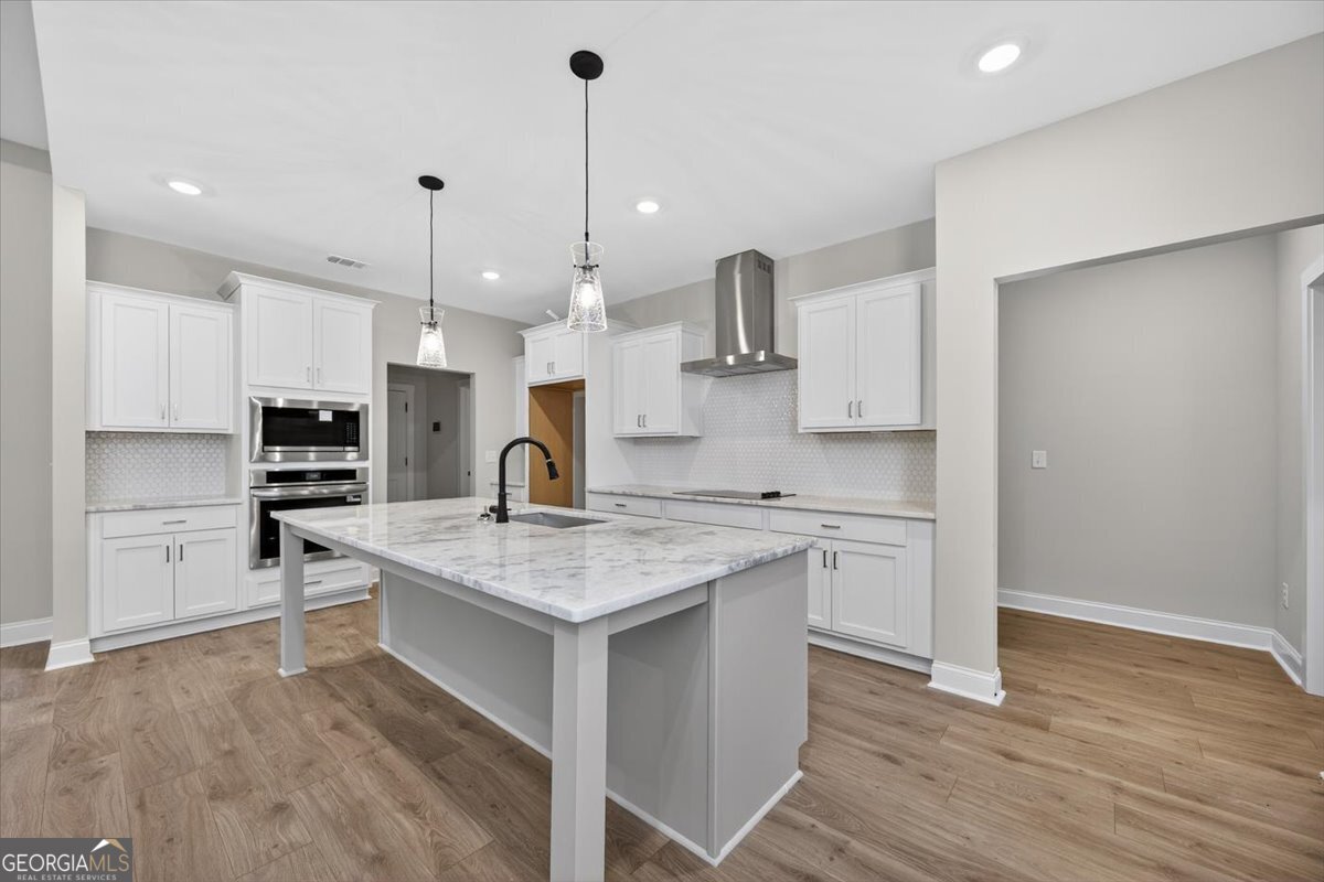 98 Mud Bridge Road The Rock, GA 30285 - Photo 12 of 47 a kitchen with stainless steel appliances granite countertop a sink stove and wooden floor