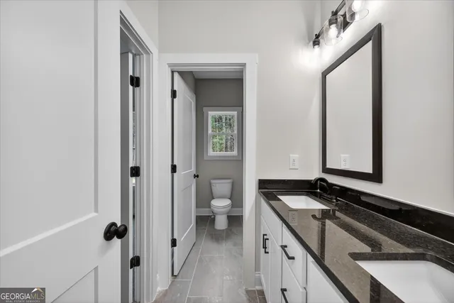 a bathroom with a granite countertop sink and a mirror