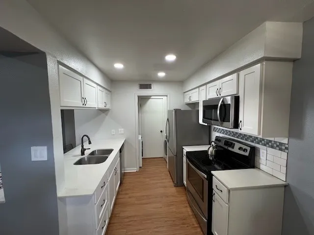 an empty room with windows and ceiling fan
