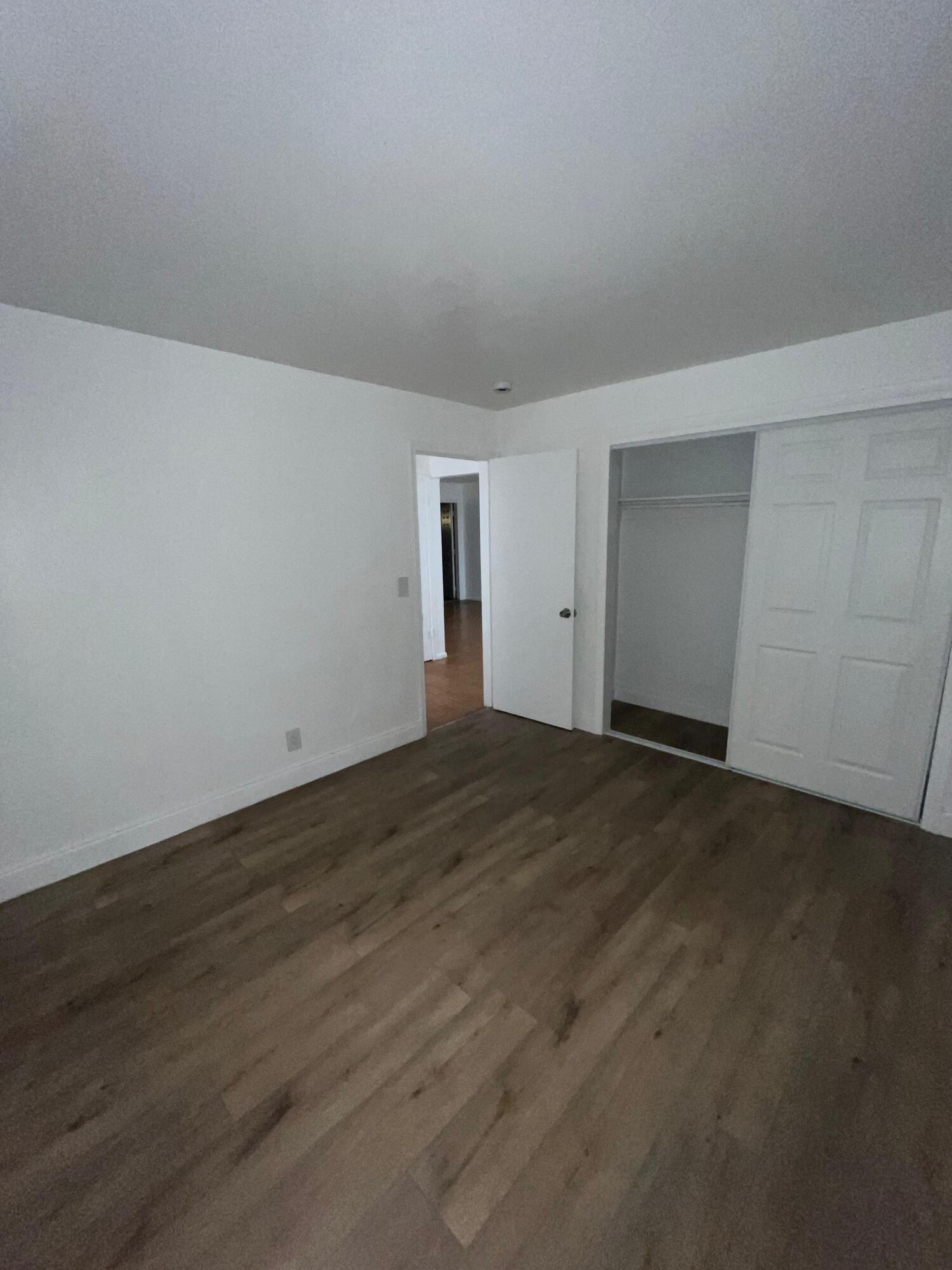 a view of an empty room and wooden floor