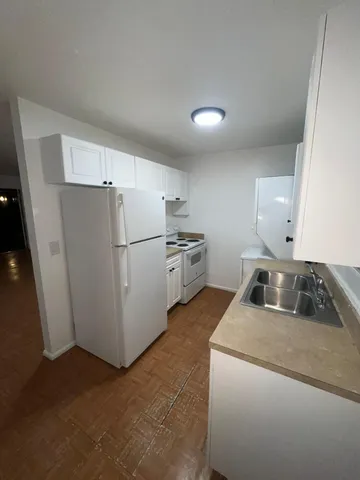 a kitchen with a refrigerator sink and cabinets
