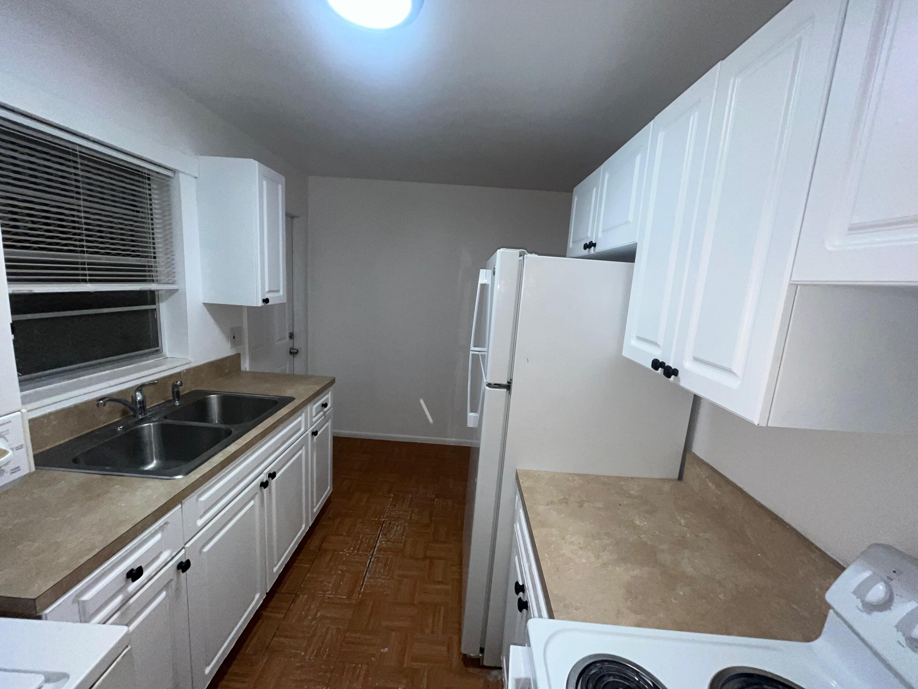 1245 West 35th Street, Unit 4 Riviera Beach, FL 33404 - Photo 4 of 11 a kitchen with granite countertop a refrigerator and a sink