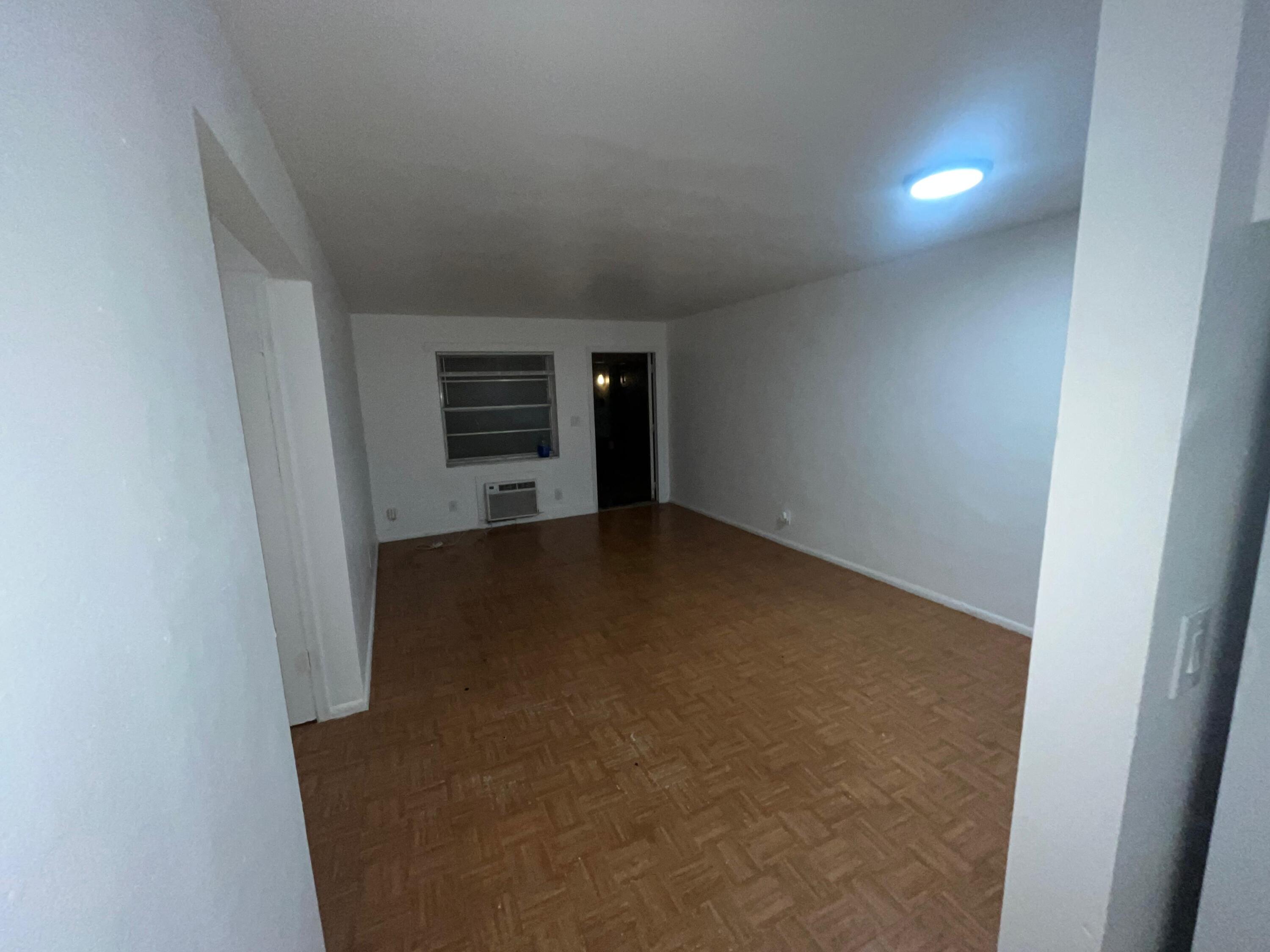 1245 West 35th Street, Unit 4 Riviera Beach, FL 33404 - Photo 7 of 11 a view of a kitchen with an empty space and a hallway