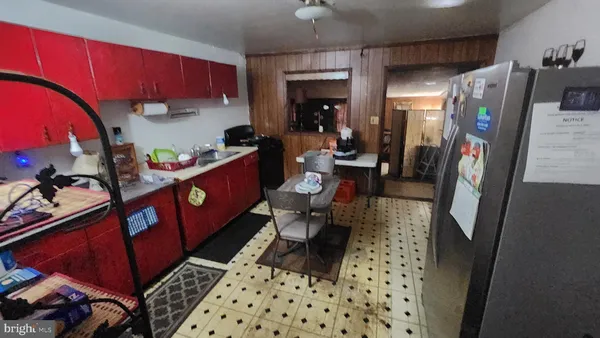 a kitchen with stainless steel appliances a refrigerator a stove a sink and a dining table