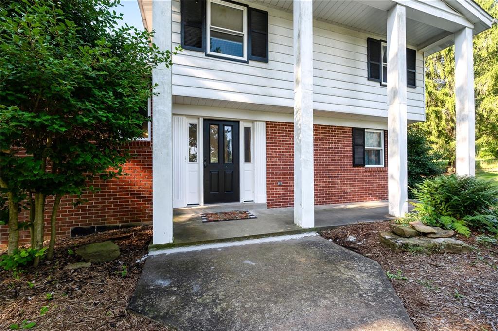a view of a brick house with a large windows and a large tree